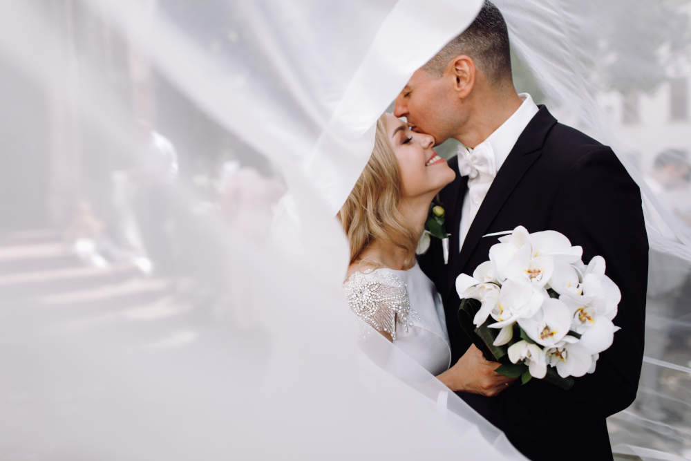 groom-black-tuxedo-hugs-tender-stunning-bride-while-they-standQ